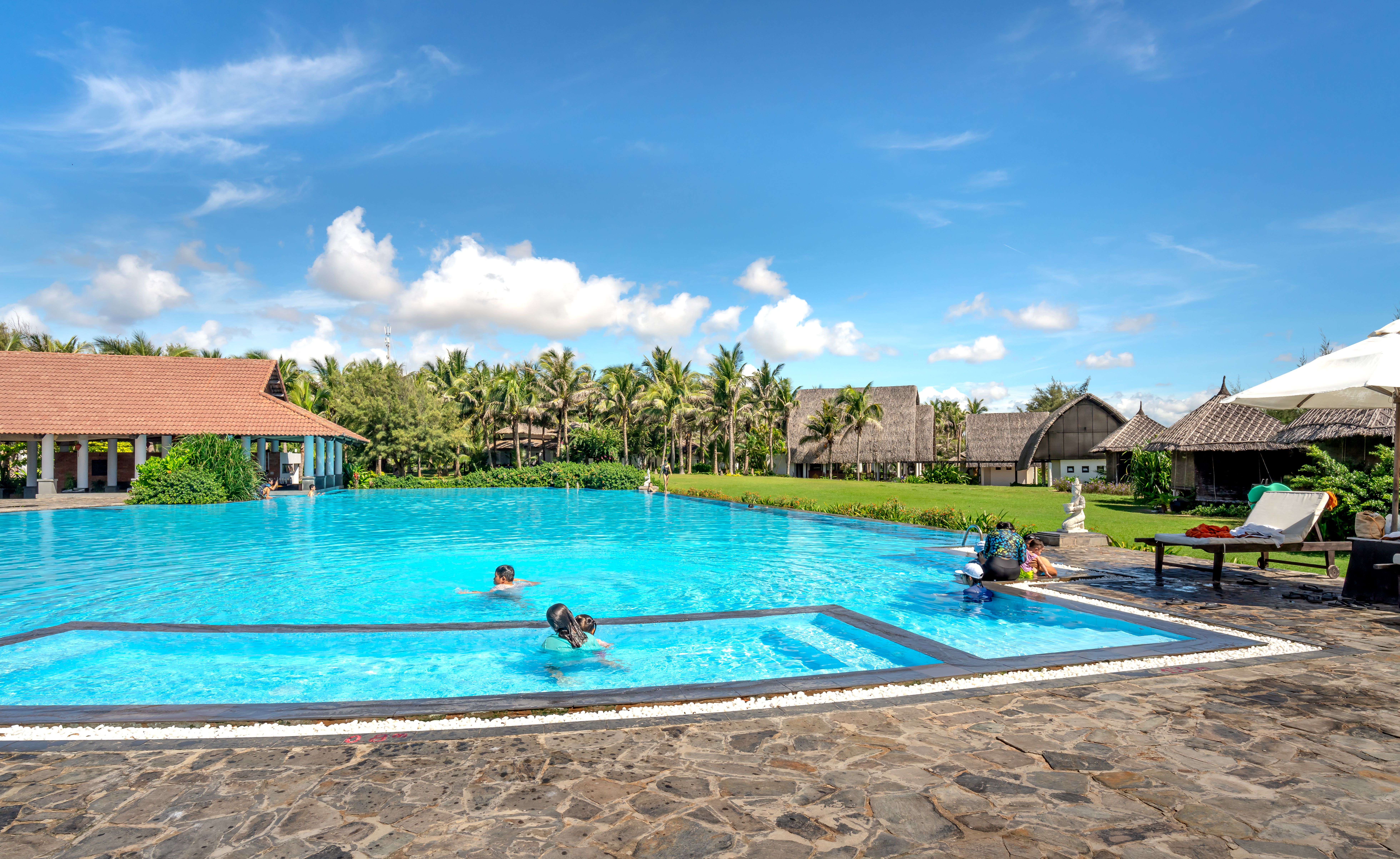 Professional pool technician cleaning a resort pool